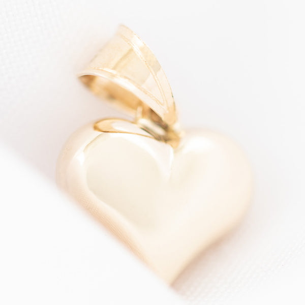 Dije hueco motivo corazón en oro amarillo 14 kilates.