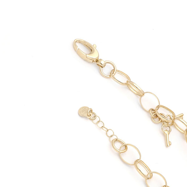 Pulsera eslabón cruzado con colgantes motivo corazón y llaves en oro amarillo 14 kilates.