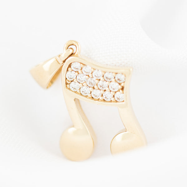 Dije diseño especial motivo nota musical con circonias en oro amarillo 14 kilates.