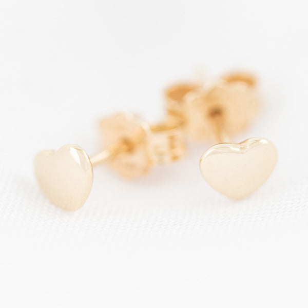 Aretes lisos motivo corazón en oro amarillo 14 kilates.