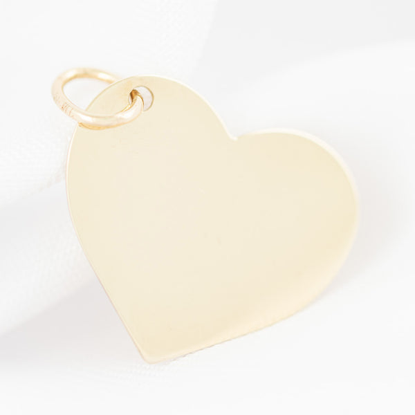 Dije liso motivo corazón en oro amarillo 14 kilates.