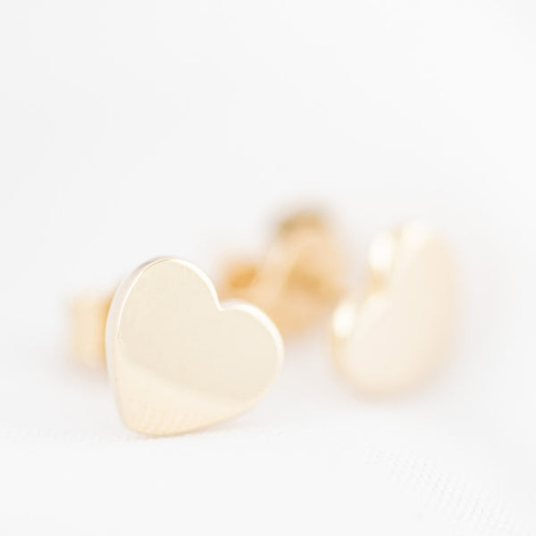 Aretes lisos motivo corazón en oro amarillo 14 kilates.
