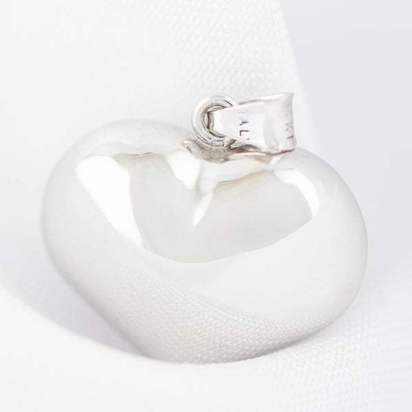 Dije hueco motivo corazón en oro blanco 14 kilates.