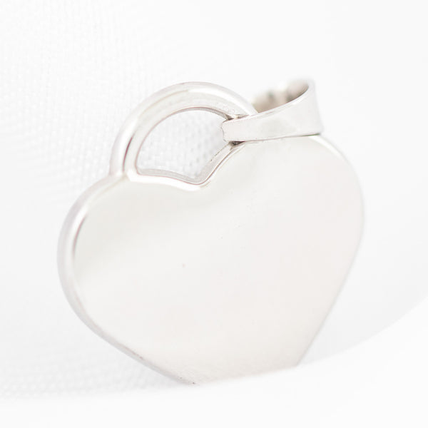 Dije liso motivo corazón en oro blanco 14 kilates.