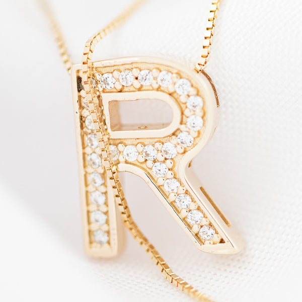 Gargantilla eslabón cuadrado cruzado con dije diseño especial motivo letra R y circonias en oro amarillo 14 kilates.