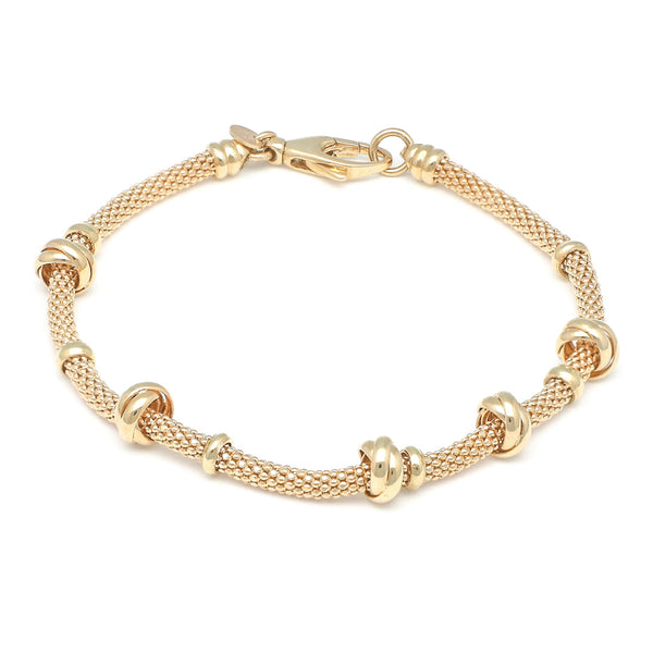 Pulsera eslabón tejido con aplicaciones en oro amarillo 14 kilates.