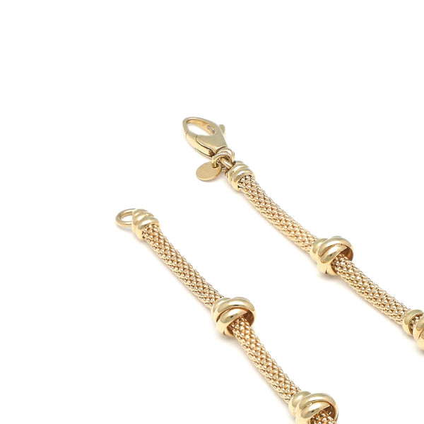 Pulsera eslabón tejido con aplicaciones en oro amarillo 14 kilates.