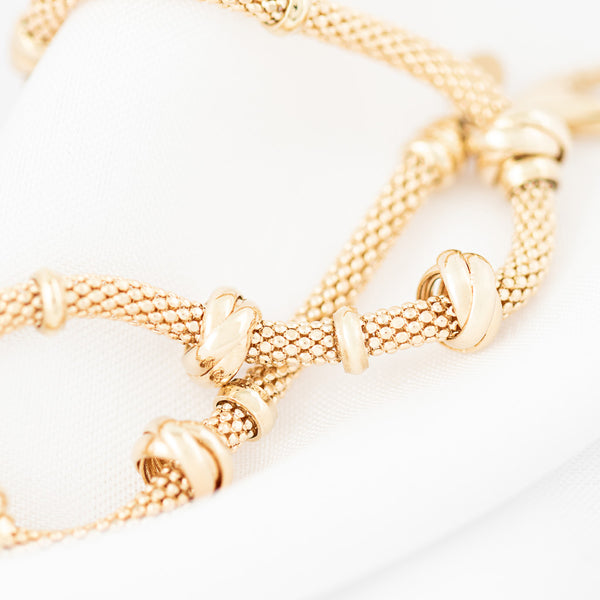 Pulsera eslabón tejido con aplicaciones en oro amarillo 14 kilates.