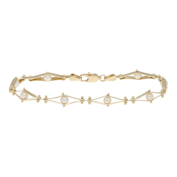 Pulsera eslabón articulado con perlas en oro amarillo 14 kilates.