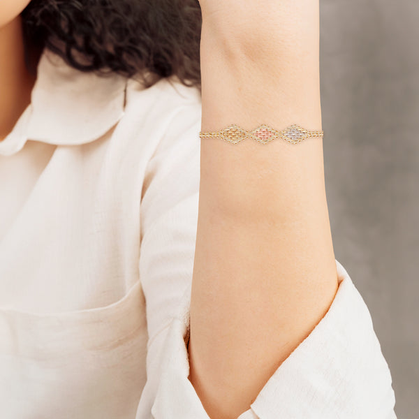 Pulsera eslabón boleado con aplicaciones en oro tres tonos 14 kilates.