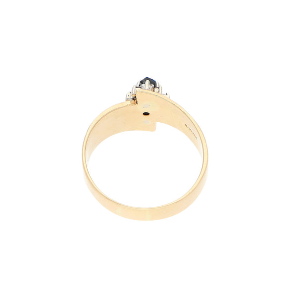 Anillo estilizado con diamantes y zafiro en oro dos tonos 14 kilates.
