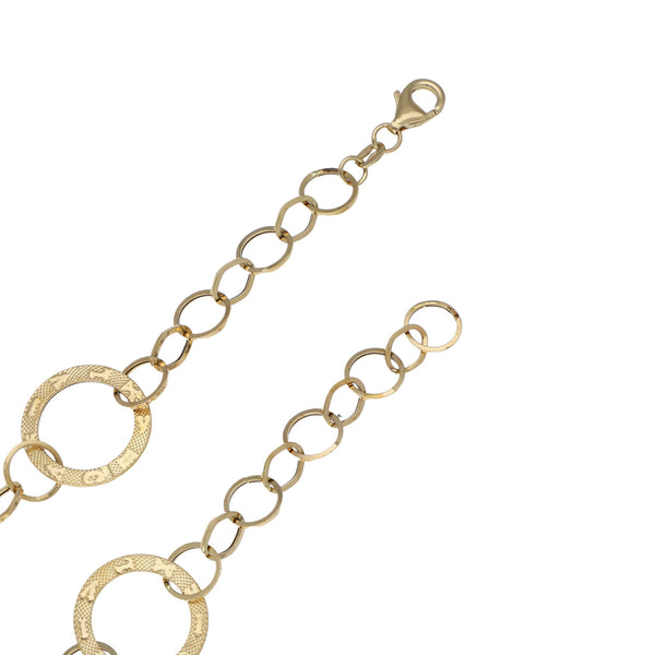 Juego de gargantilla, pulsera eslabón cruzado y broqueles con aplicación motivo aros en oro amarillo 14 kilates.