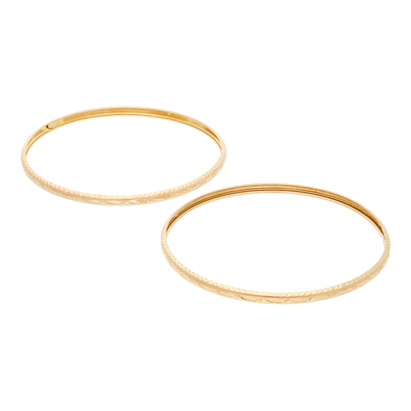 Dos pulseras de arillo labradas en oro amarillo 14 kilates.