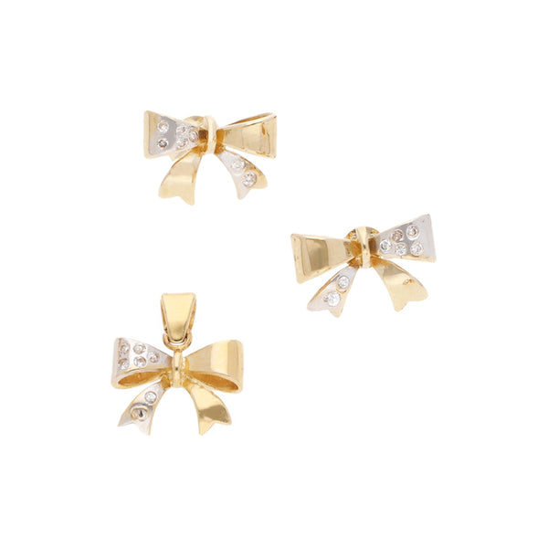 Juego de dije y aretes diseño especial con circonias motivo moño en oro amarillo 14 kilates.