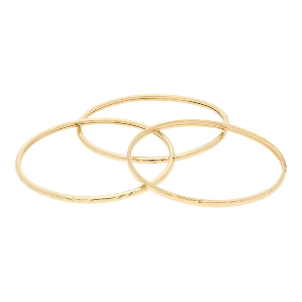 Tres pulseras de arillo labradas en oro amarillo 14 kilates.