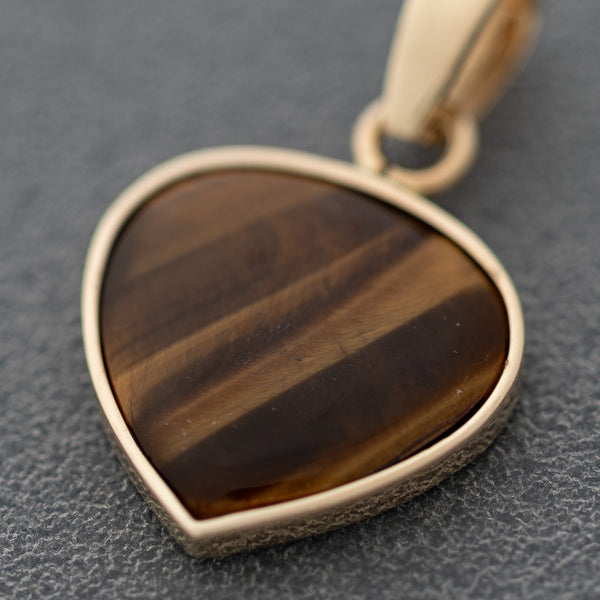 Juego de dije y aretes diseño especial con ojo de tigre y circonias en oro amarillo 14 kilates.