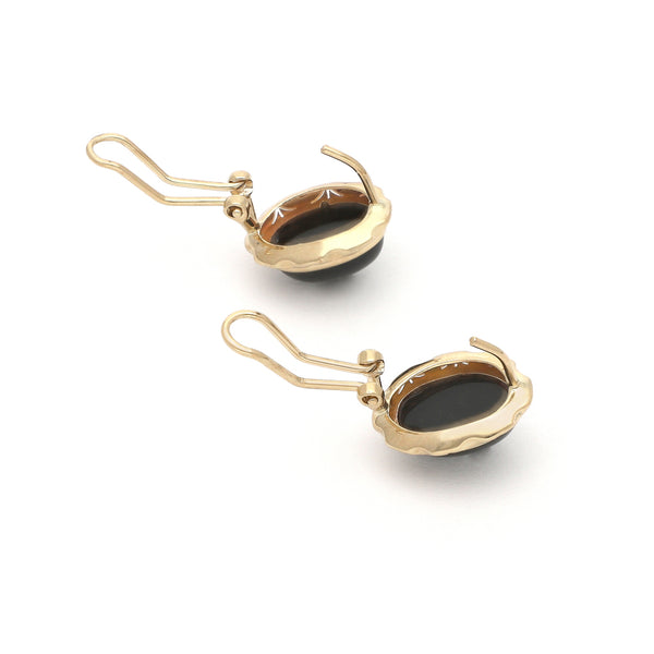 Juego de anillo y aretes calados con ónix en oro amarillo 14 kilates.