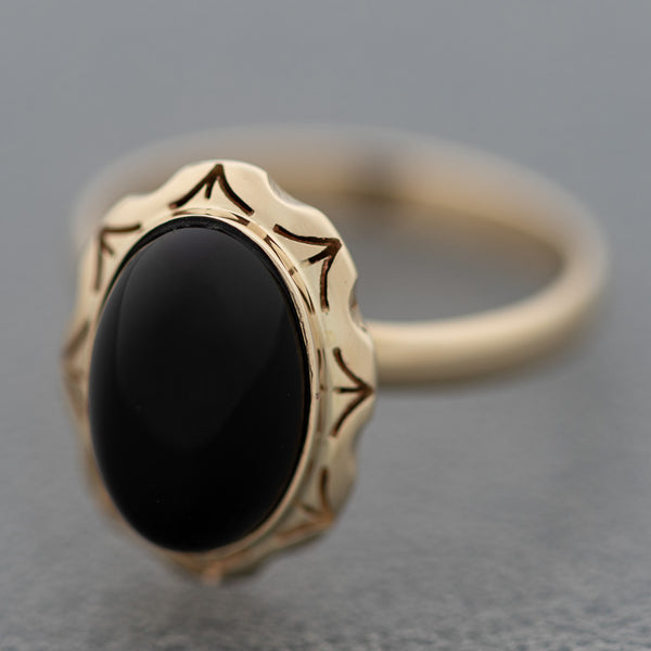 Juego de anillo y aretes calados con ónix en oro amarillo 14 kilates.