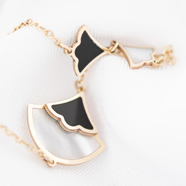 Pulsera eslabón cruzado con aplicaciones motivo abanico con sintéticos en oro amarillo 14 kilates.