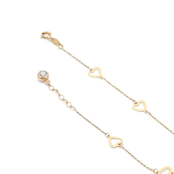 Pulsera eslabón cruzado con aplicaciones motivo corazón y sintético en oro amarillo 14 kilates.