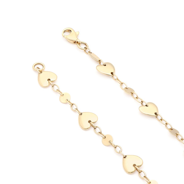 Pulsera eslabón cruzado con aplicaciones motivo corazón en oro amarillo 14 kilates.