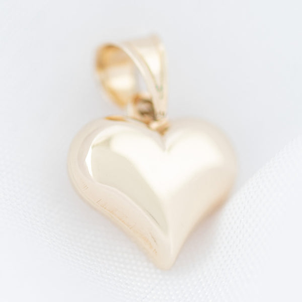 Dije hueco motivo corazón en oro amarillo 14 kilates.