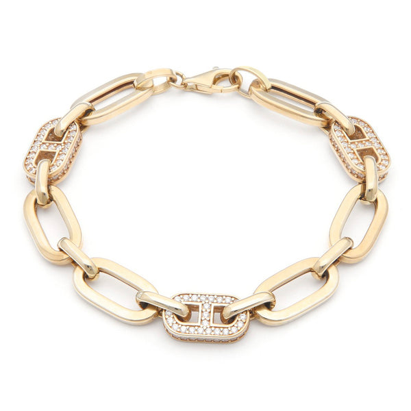 Pulsera eslabón cruzado con aplicaciones de circonias en oro amarillo 14 kilates.
