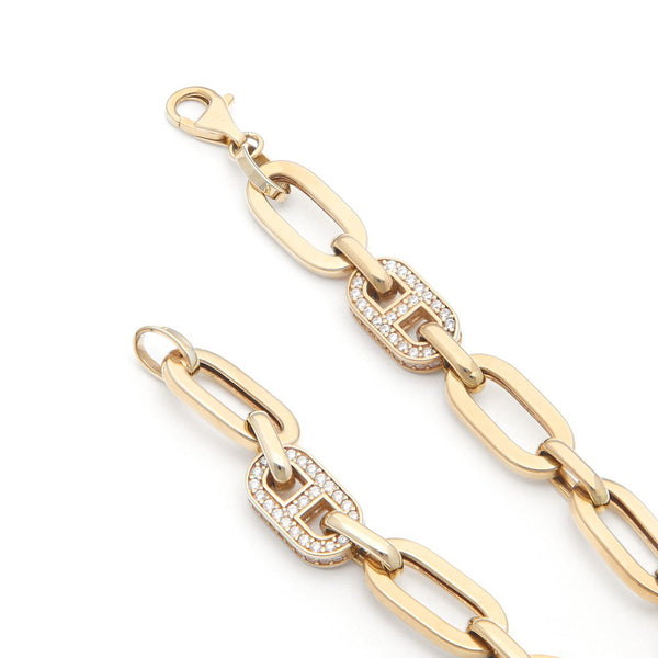 Pulsera eslabón cruzado con aplicaciones de circonias en oro amarillo 14 kilates.