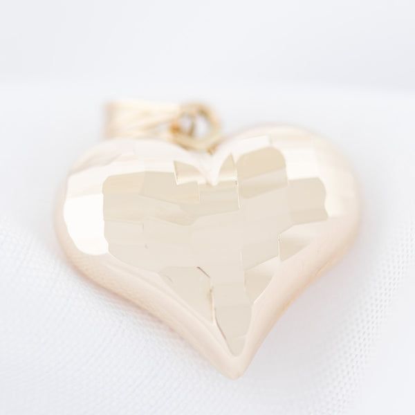 Dije facetado motivo corazón en oro amarillo 14 kilates.