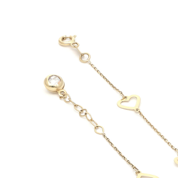 Pulsera eslabón cruzado con aplicaciones motivo corazón y sintético en oro amarillo 14 kilates.