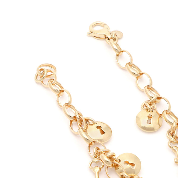 Pulsera eslabón combinado con colgantes motivo llave y cerradura en oro amarillo 14 kilates.