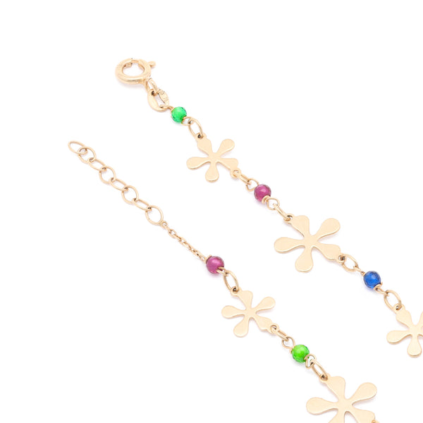 Pulsera eslabón cruzado con sintéticos y aplicaciones motivo flor en oro amarillo 14 kilates.