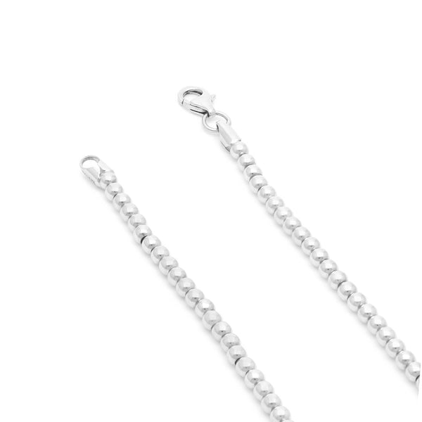Pulsera eslabón cruzado con aplicaciones motivo esferas en oro blanco 14 kilates.