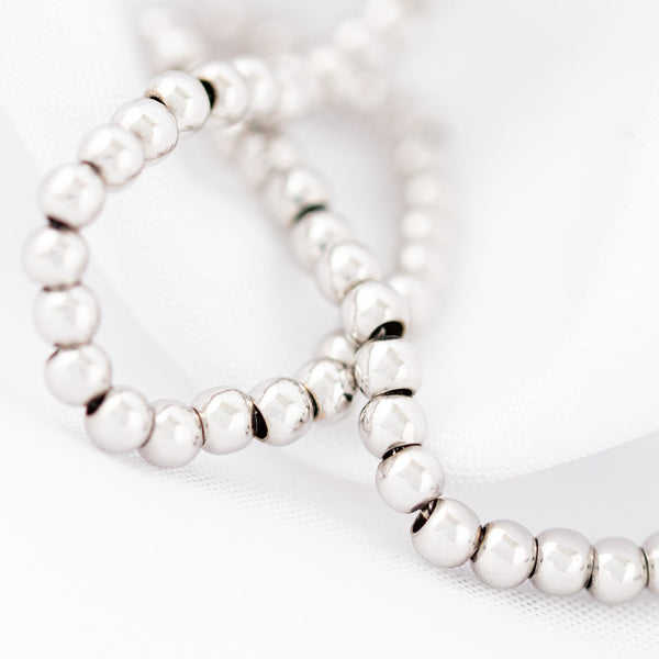 Pulsera eslabón cruzado con aplicaciones motivo esferas en oro blanco 14 kilates.