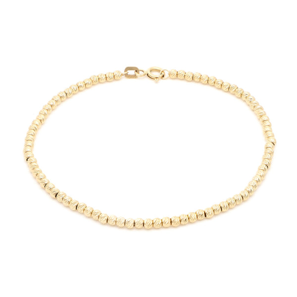 Pulsera eslabón cruzado con aplicaciones motivo esferas en oro amarillo 14 kilates.