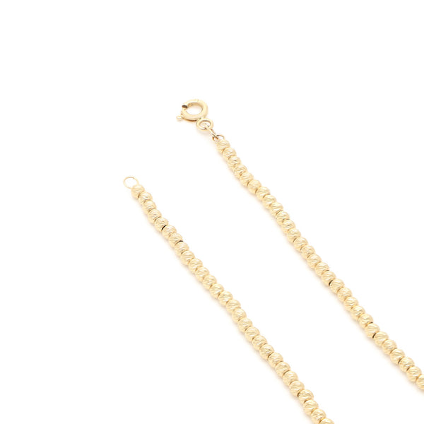 Pulsera eslabón cruzado con aplicaciones motivo esferas en oro amarillo 14 kilates.