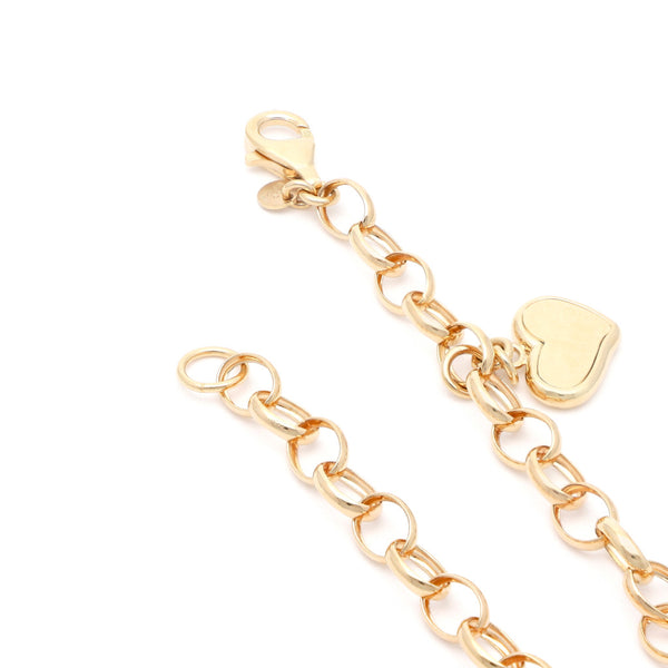 Pulsera eslabón cruzado con colgante motivo corazón en oro amarillo 14 kilates.