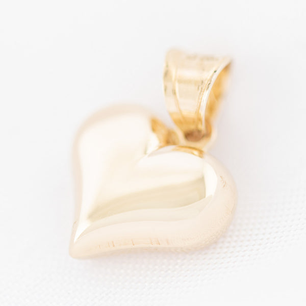 Dije hueco motivo corazón en oro amarillo 14 kilates.