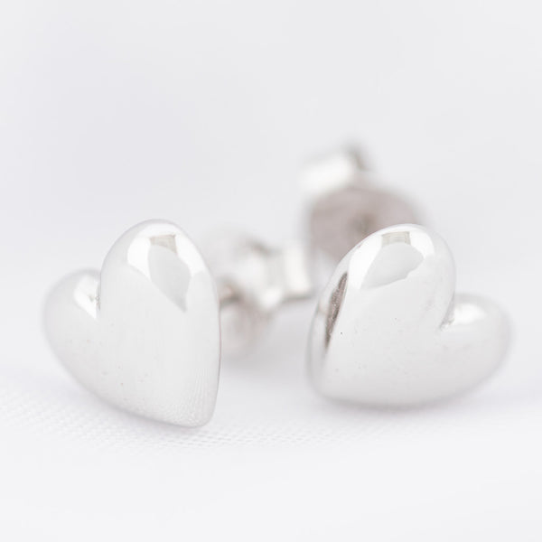 Aretes lisos motivo corazón en oro blanco 14 kilates.