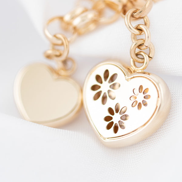 Pulsera eslabón cruzado con colgantes motivo corazón en oro amarillo 14 kilates.