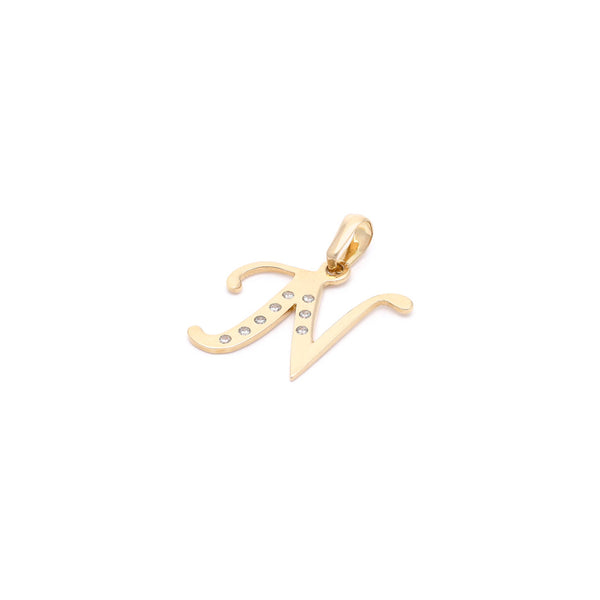 Dije diseño especial motivo letra N con circonias en oro amarillo 14 kilates.