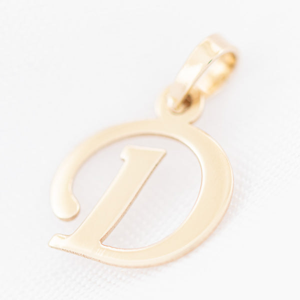 Dije liso motivo letra D en oro amarillo 14 kilates.