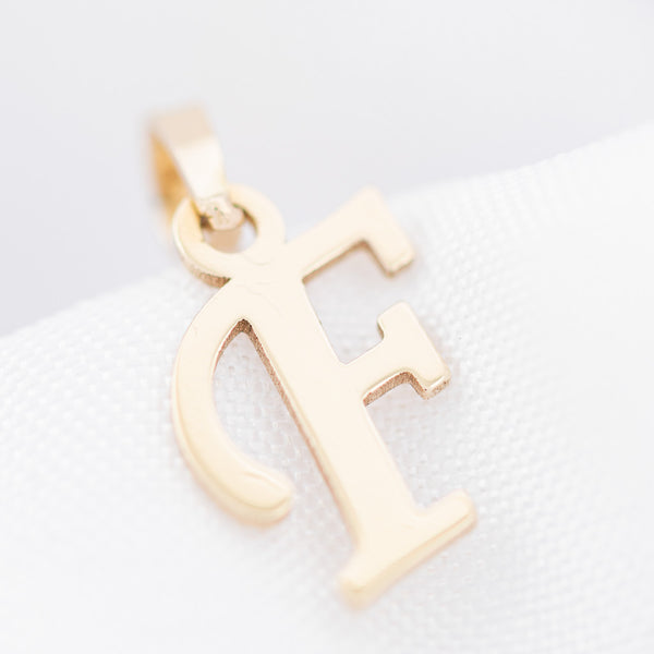 Dije liso motivo letra F en oro amarillo 14 kilates.