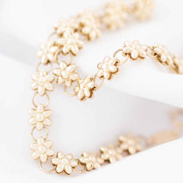 Pulsera eslabón combinado motivo flor en oro amarillo 14 kilates.