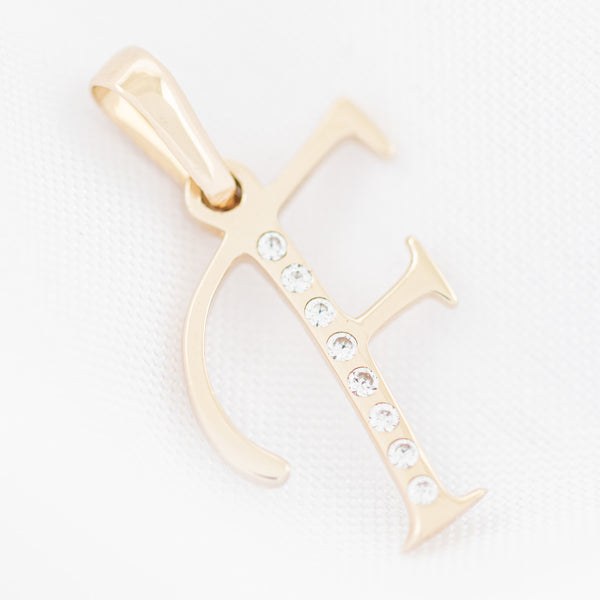 Dije diseño especial motivo letra F con circonias en oro amarillo 14 kilates.