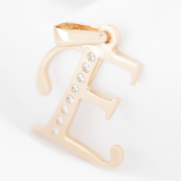 Dije diseño especial motivo letra E con circonias en oro amarillo 14 kilates.