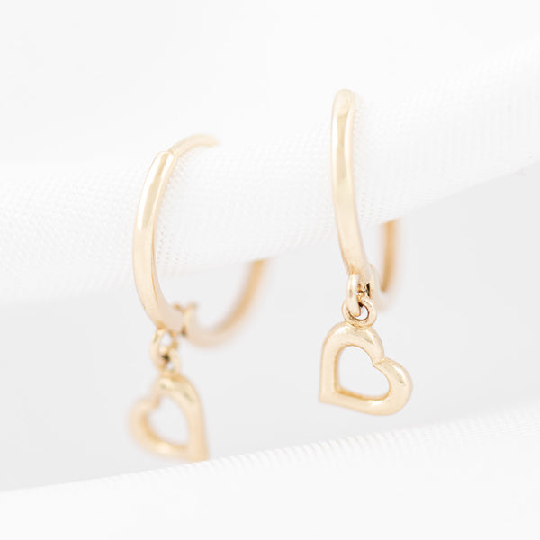 Arracadas lisas con colgantes motivo corazón en oro amarillo 14 kilates.