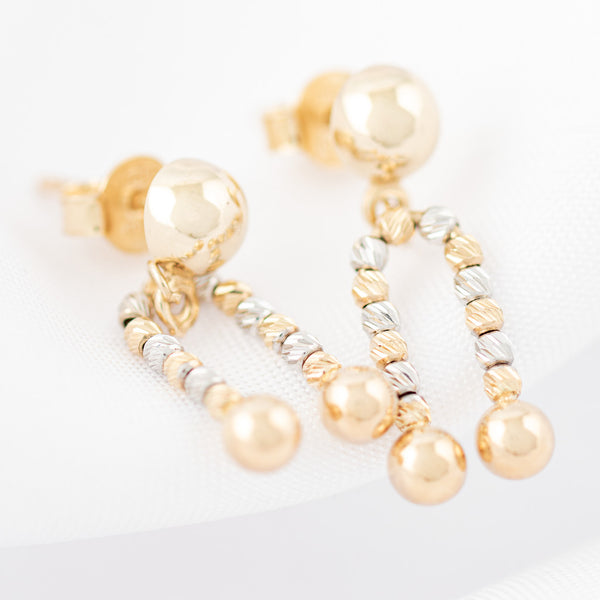 Aretes boleados con colgantes en oro dos tonos 14 kilates.