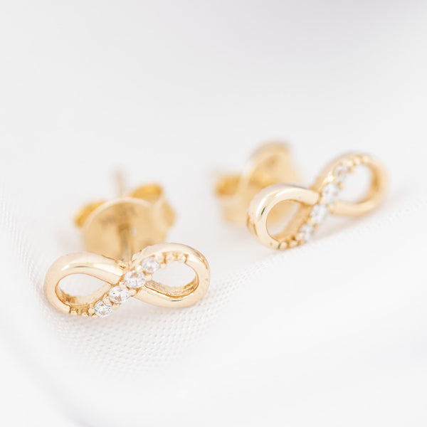 Aretes diseño especial con circonias motivo infinito en oro amarillo 14 kilates.