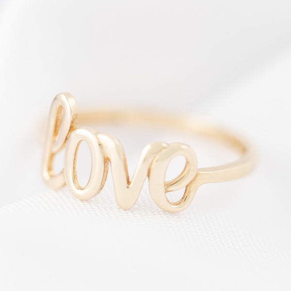 Anillo liso motivo letras love en oro amarillo 14 kilates.